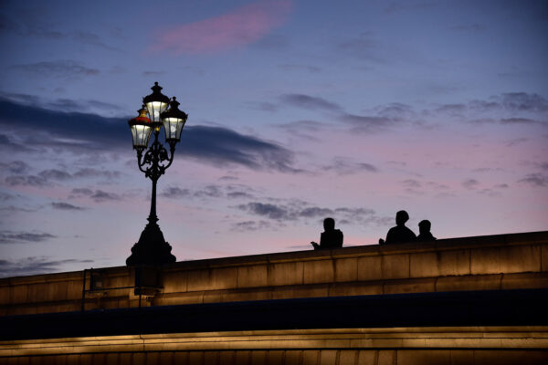 Photography silhouette technique - dramatic and colourful sunset over Putney Bridge, people walking over the bridge during the blue hour
